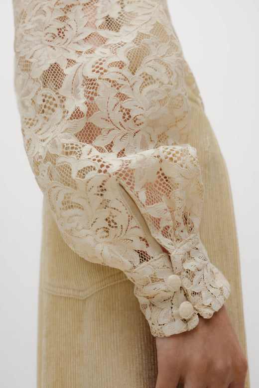 Close-up of a beige lace sleeve on a neutral background