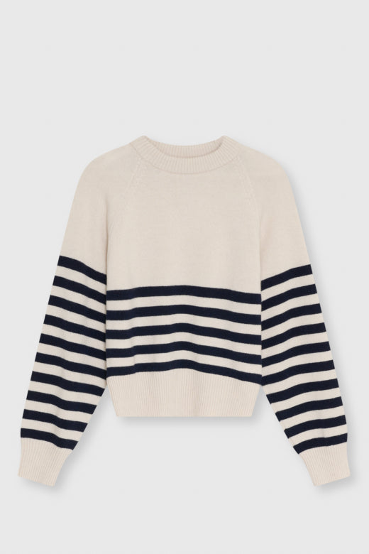 A cream-colored knit sweater with navy blue horizontal stripes on the sleeves and across the chest, displayed against a light gray background.